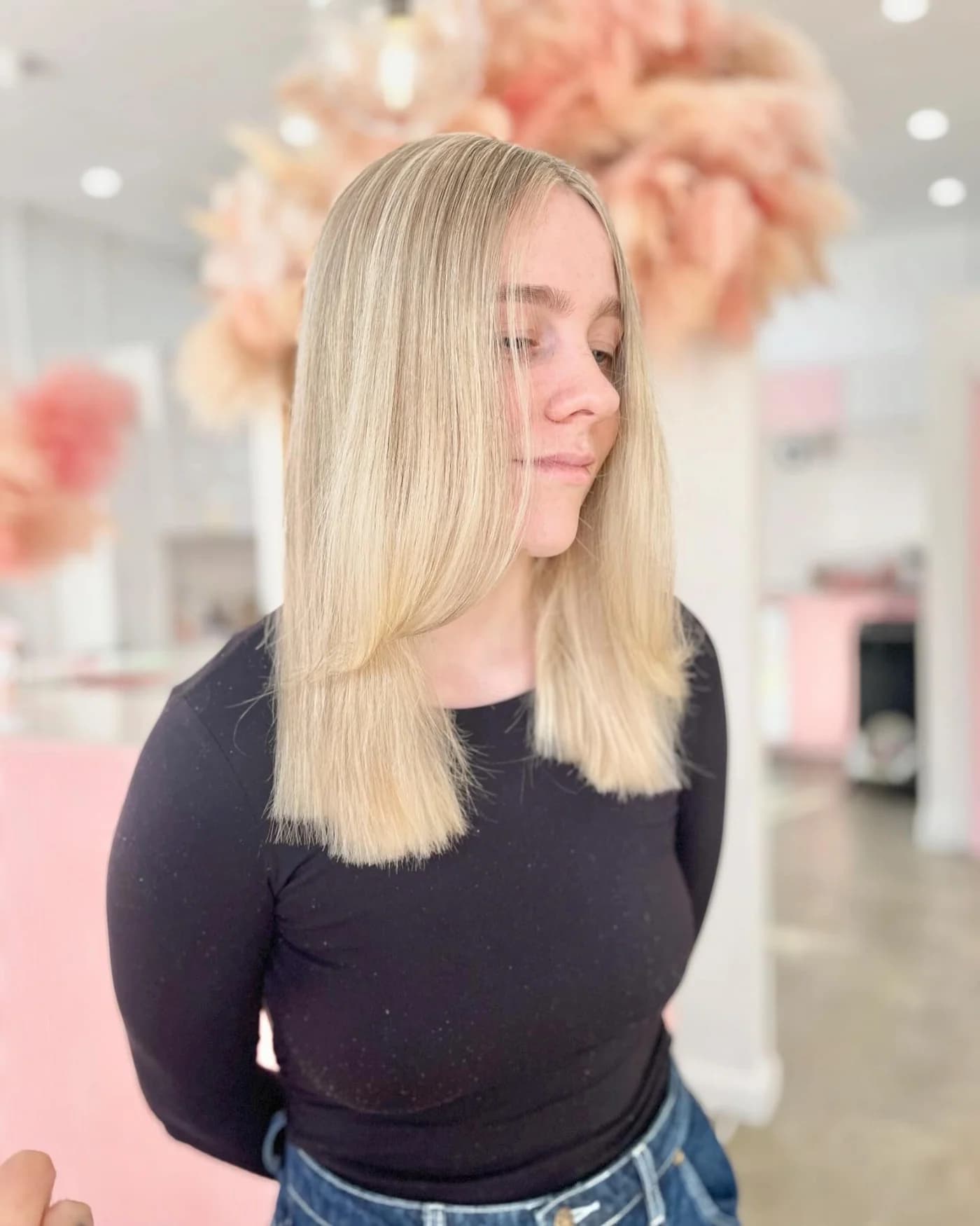 Straight, shoulder-length blonde hair with a soft centre part