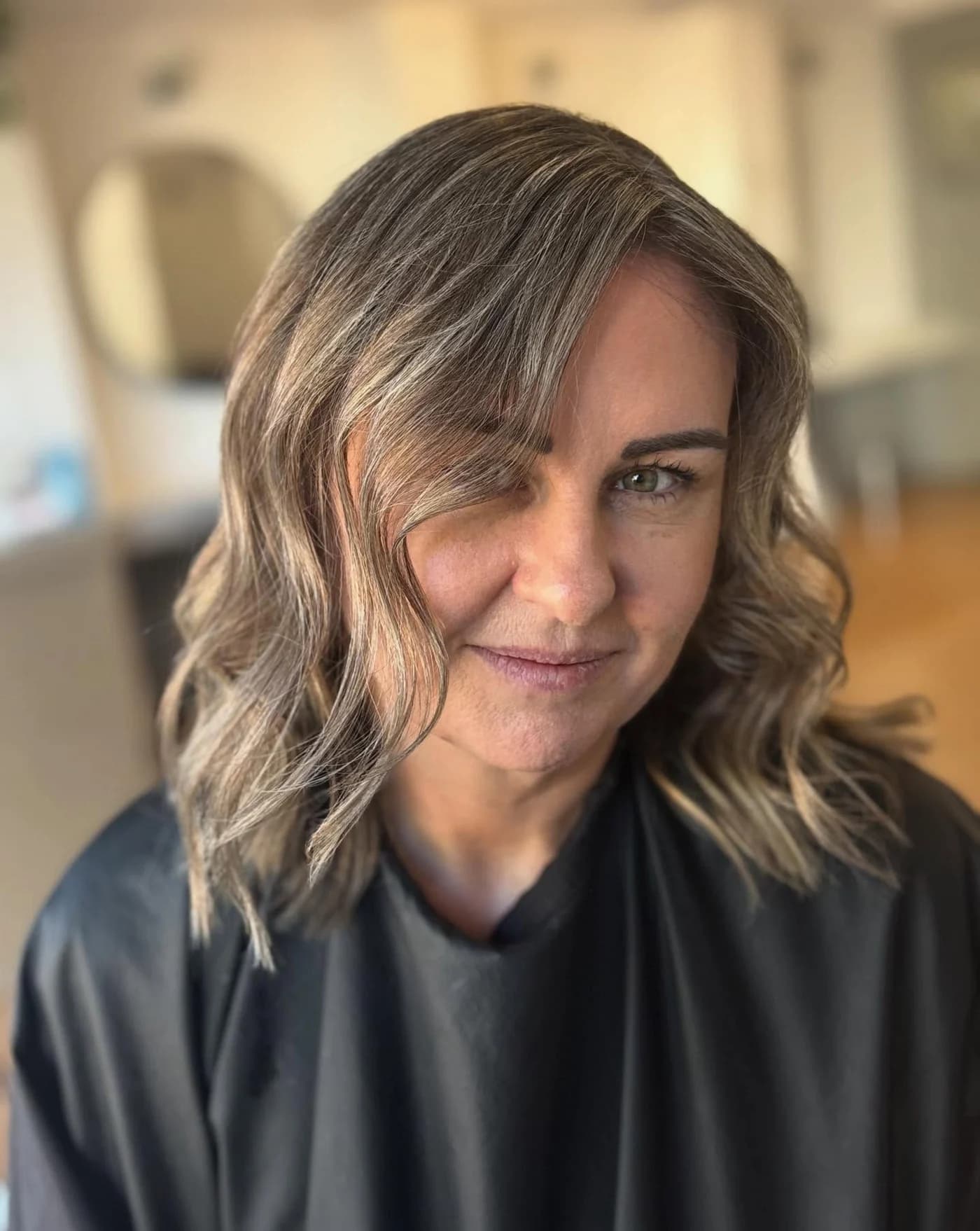 Dimensional shoulder-length brunette hair styled in soft waves