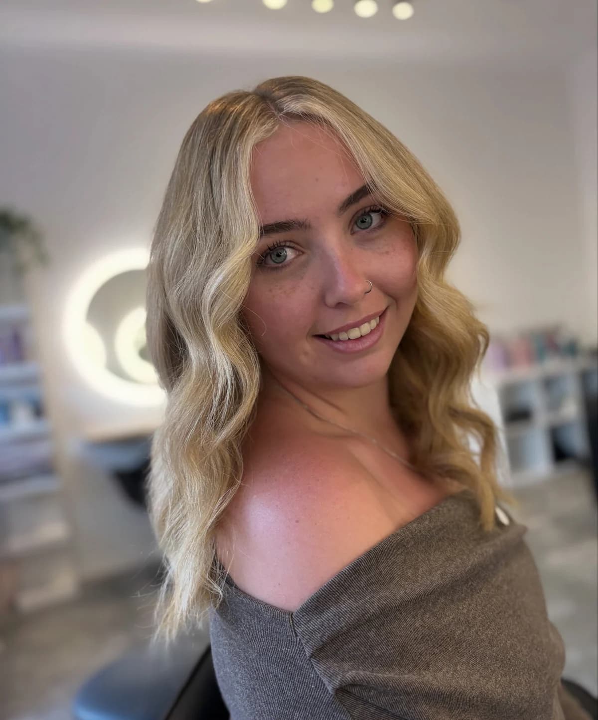 Long blonde hair styled in loose waves with face-framing layers