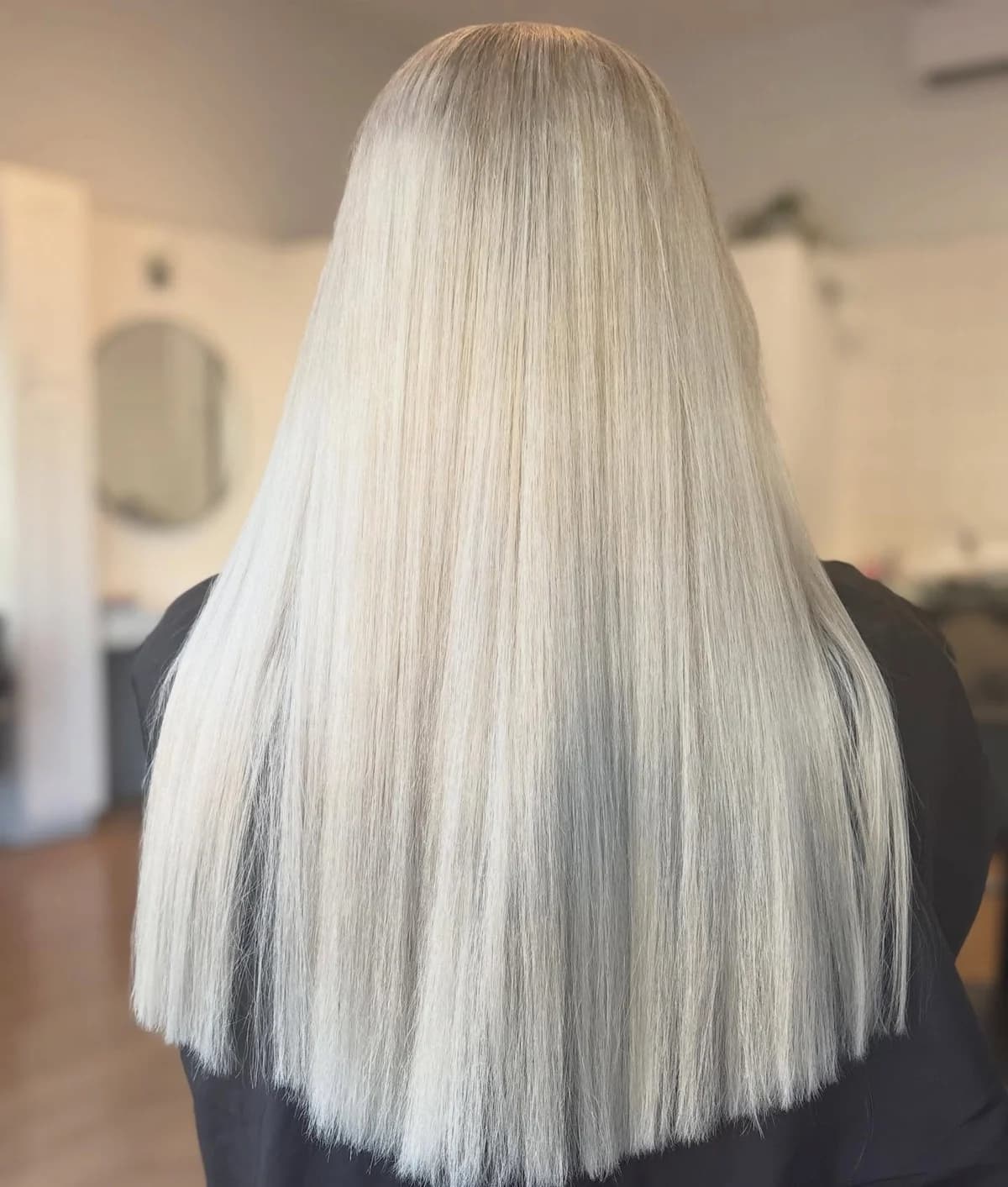 Long pale blonde hair with a clean, straight finish, viewed from the back