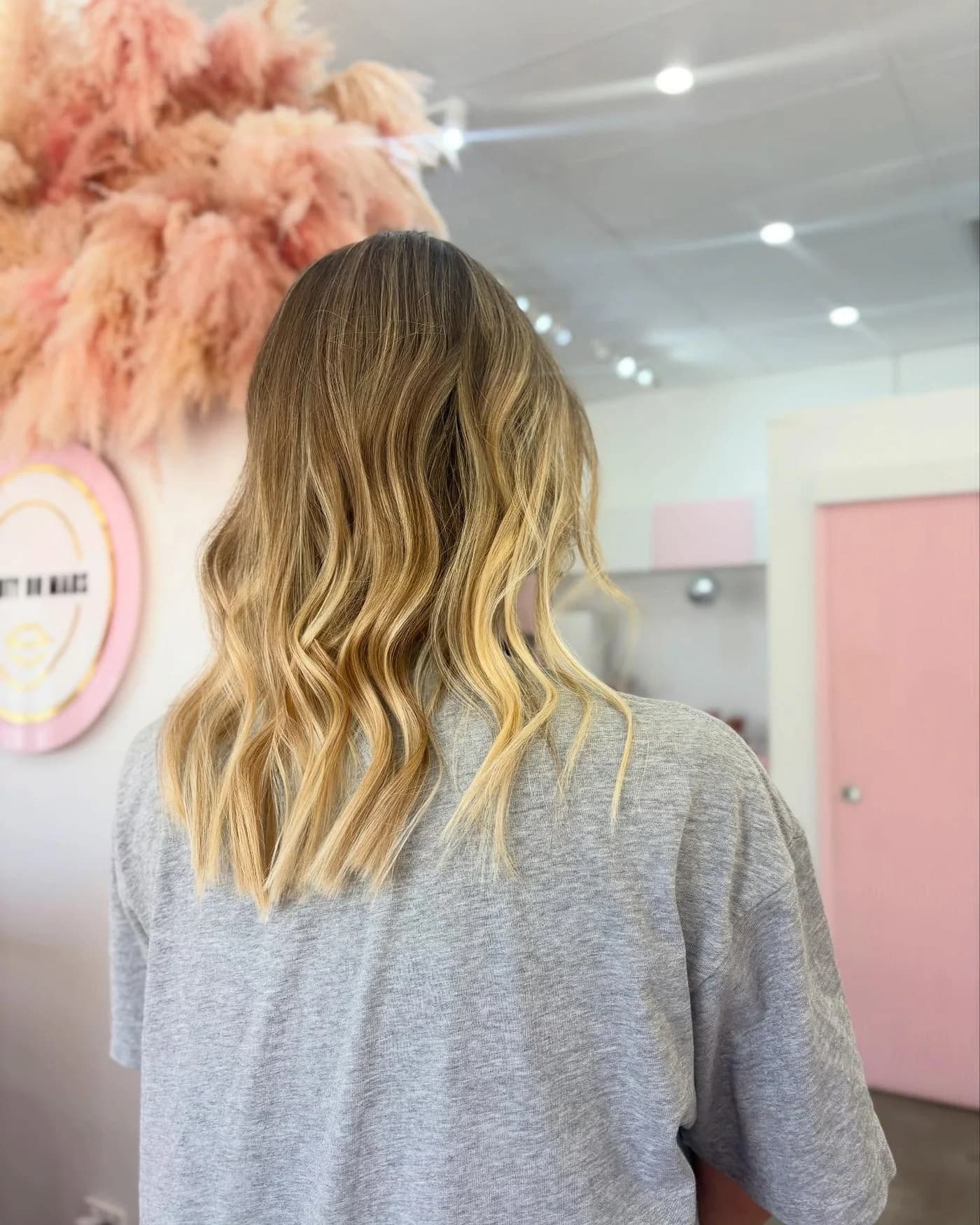 Long golden blonde hair blended from a darker root and finished in waves