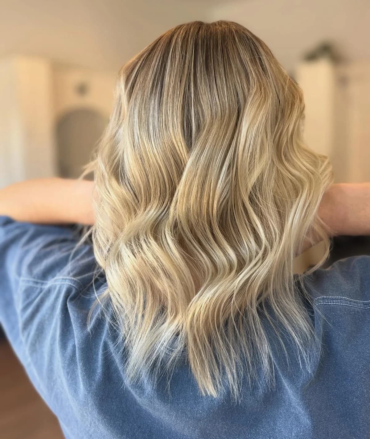 Dimensional blonde foils finished in soft waves, shown from the back