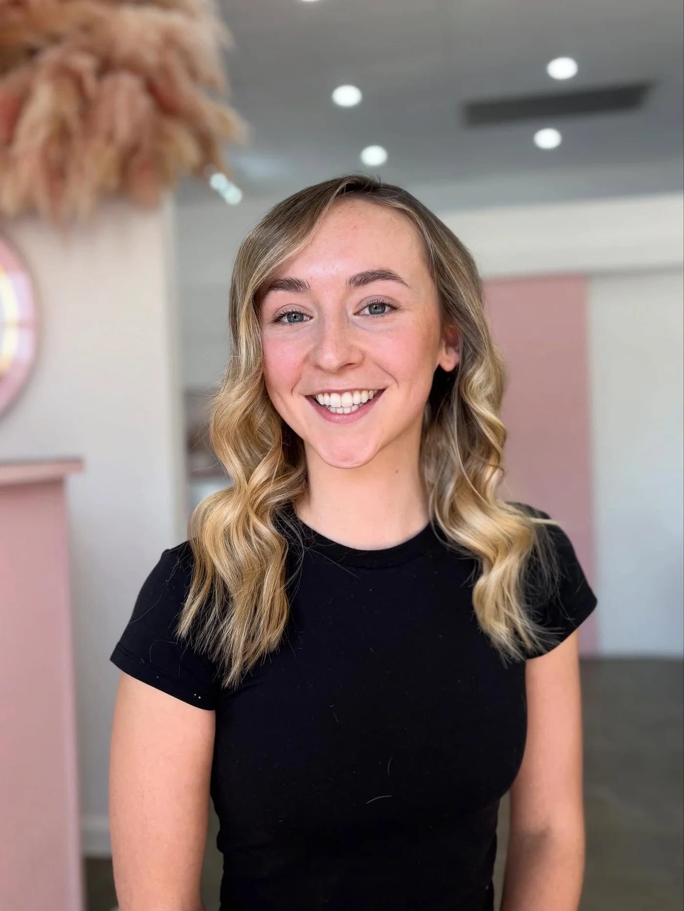 Client with long blonde highlights and a soft curled finish