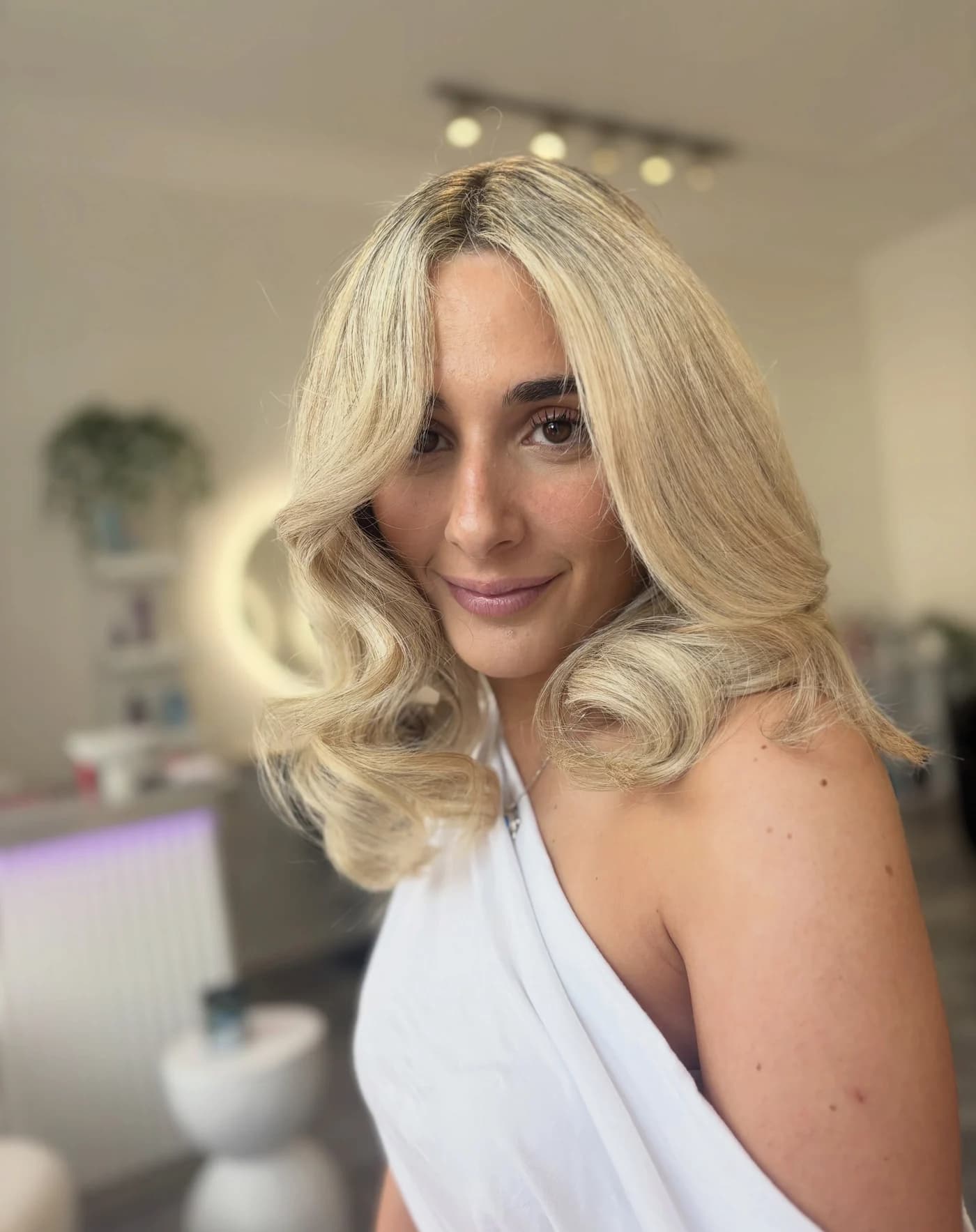 Blonde client with a bouncy blowout and soft face-framing layers